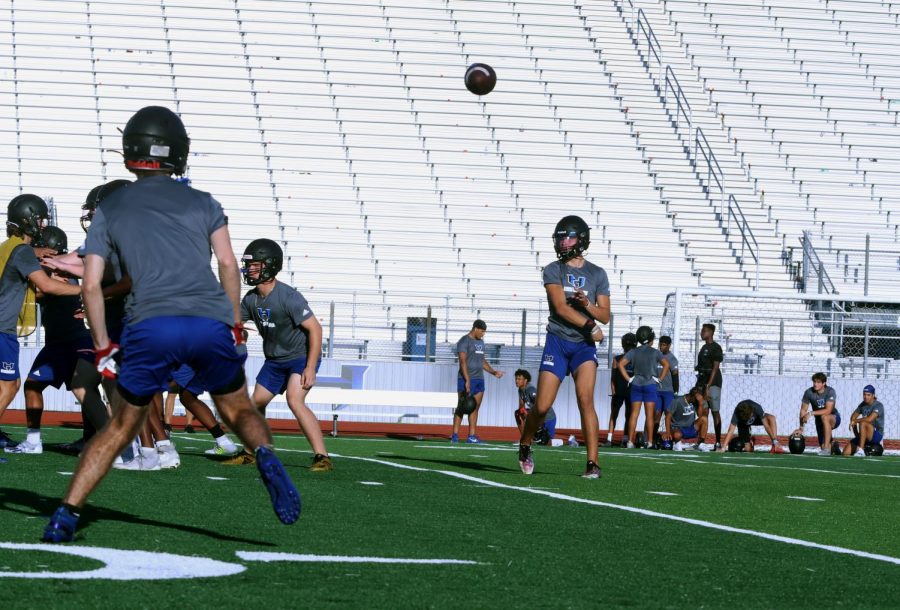 Quarterback+Braxton+Baker+passes+the+ball+to+his+teammate+during+practice+before+school+on+Aug.+25.+The+team+practiced+a+variety+of+new+plays+in+preparation+for+the+upcoming+game+against+Guyer+in+hopes+to+defeat+them%2C+unlike+last+year.+