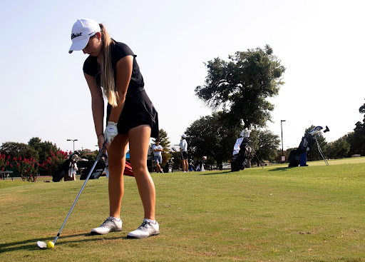 Senior Nina Gudgeon lines up the ball before she swings. With the golf tournament season starting, all of the golf teams have been preparing for upcoming competitions.