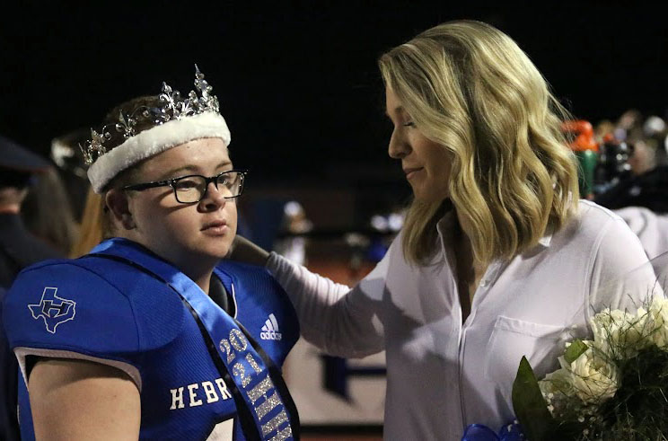 Senior Brady Vaughn won Homecoming king on Oct. 22. He looks to the crowd as his sister stands to his side and supports him. 