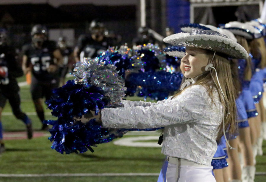 Junior captain Caroline Holloway stands with the Silver Wings as the football team enters the field on Oct. 29. Following the conclusion of football season, the Silver Wings begin preparing for their competitive season and will later transition into their spring show. 