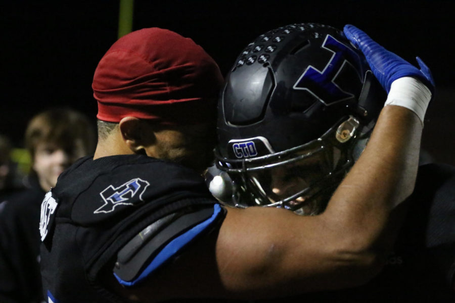 Senior Joe Onuwabhagbe congratulates junior Carson Dean. Dean, a middle linebacker, intercepted the ball and ran it in to score a touchdown.