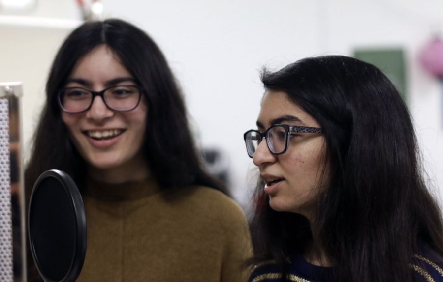 Junior twins, Aaliya and Asta Lalani, talk into the microphone. 