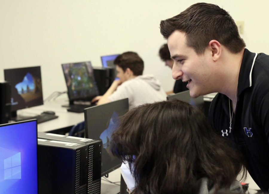 Chemistry teacher and esports sponsor, Jaden Gorham helps junor Bryce Hall to complete his set up for the five-to-five esports competition that all Gorham’s students participated in during his fourth period esports class.