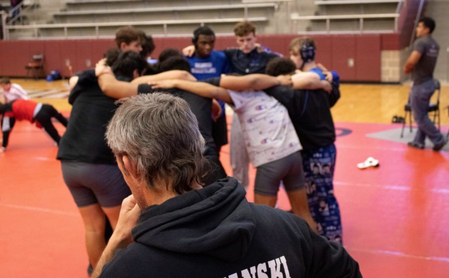 Head+coach+David+Rozanski+and+the+wrestling+team+perform+their+pre-game+ritual+before+the+district+matches+on+Feb.+5.