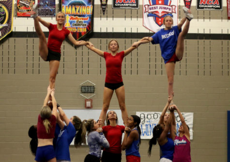 Junior Reece Hajek (left), sophomore Addison Carter (middle) and senior Avery Yarbrough practice stunting with their team during one of their after school practices.