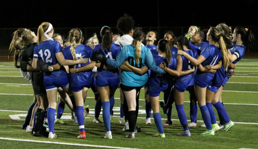 The girls soccer team does a chant before kickoff at its game against Marcus on March 4, 2022.