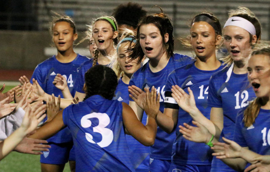 Forward Aryanna Jimson high fives her teammates as the announcer calls her name. The team lines up to cheer each other on during the introductions at each game.