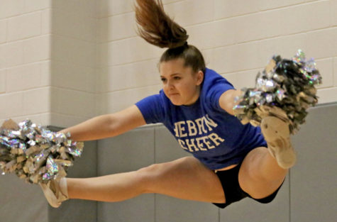 Freshman Claire Gross does a straddle jump during warm-up on March 29. Claire has been doing cheer for two years and plans on staying in Hebron Cheer all four years of high school.