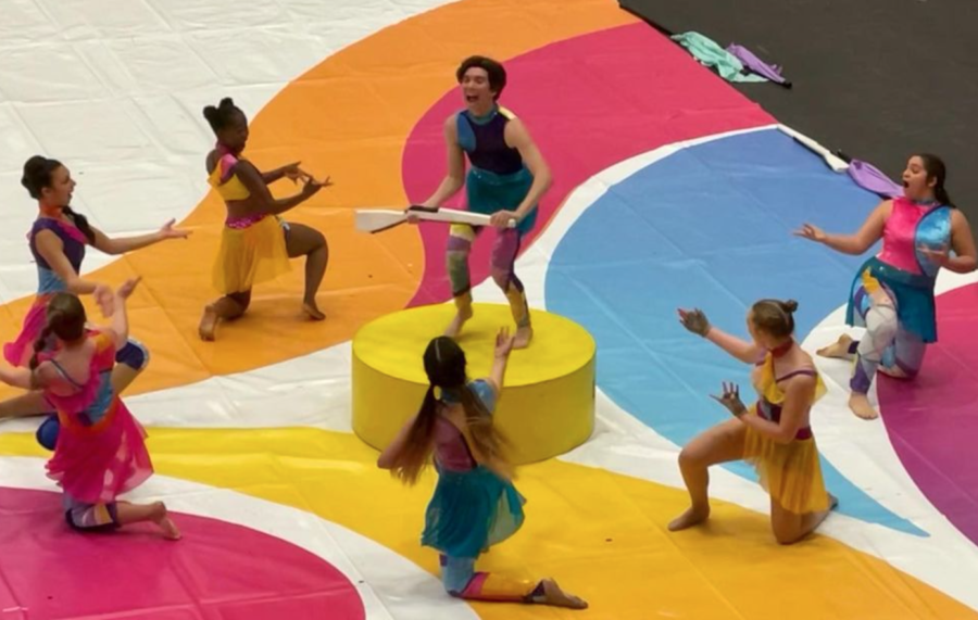 Winter guard members circle around senior Ethan Connolly as they perform their show, “Wriggle” at the LISD Color Guard Showcase on March 30. 