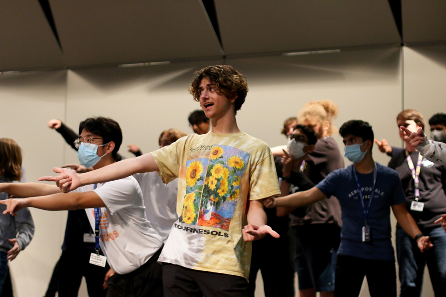 Junior Daniel Crawford points at the soloist performing at the choir’s rehearsal during fourth period. The choir will open its show with The Greatest Show for which all three choirs will perform together. 