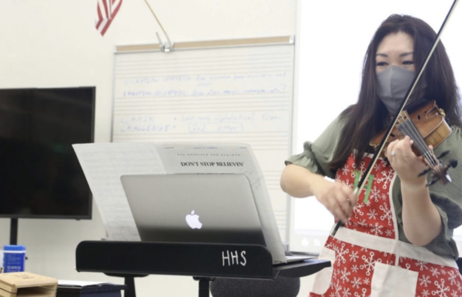 Orchestra director Helen Chang plays a section of measures of “Don’t Stop Believin” to her second period orchestra class on Sept. 8. She demonstrated how to play the section in third position to the violin section. 
