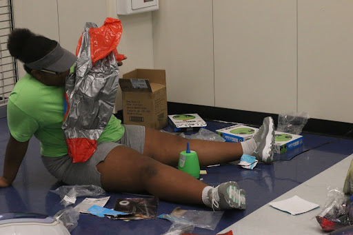 Student council officer Harmonie Alne blows up an inflatable rocket while decorating for Homecoming on Sept. 17. The rockets were hung at the entrance of the hallways on the first floor.