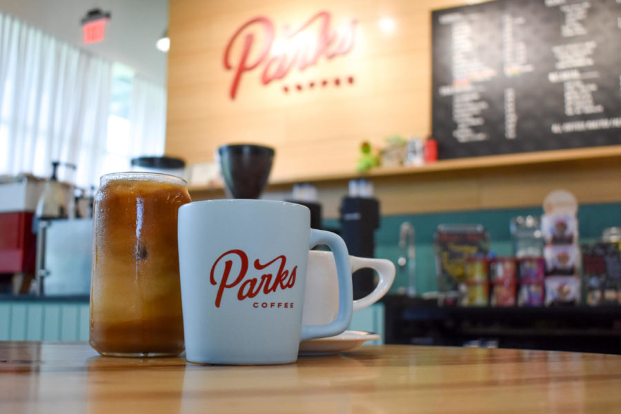 A fresh cold brew and a hot latte rest on a table at Parks Coffee.