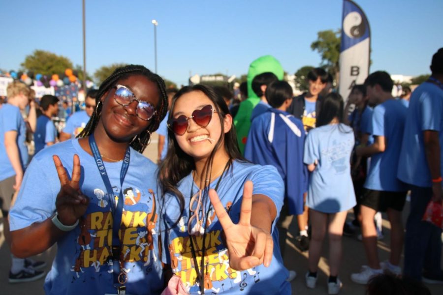 Freshmen viola players Emma Tran and Desiree Asare pose before walking with the orchestra as the parade begins. The orchestra program walked as a group, with some people in alien costumes, and featured flags for all their instrumental sections.
