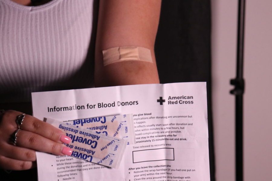 Opinion editor and social media manager Madeline Rivera holds a Red Cross blood donor form next to the arm she donated with. After her fathers life was saved by a blood transfusion, Rivera was motivated to participate in her schools blood drive to give back.