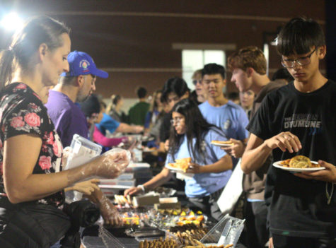 Band parents pass out desserts, pizza and drinks to the band students in front of the school after rehearsal. Trunk or Treat, an event where band parents bring food and candy for the students to simulate trick or treating, was held on Oct. 27 from 7:30 - 8:30 p.m.  
