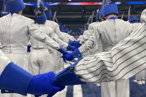 Band students hold hands on the field of the Alamodome as they await the results of the UIL 6A State Marching Band Championships. The band won second place and brought silver medals home to Hebron.