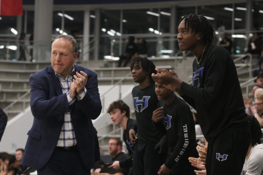 Riel and junior Isaiah Williams clap as the team scores a point. Players on the bench stand to support the team and say encouraging words throughout the game.