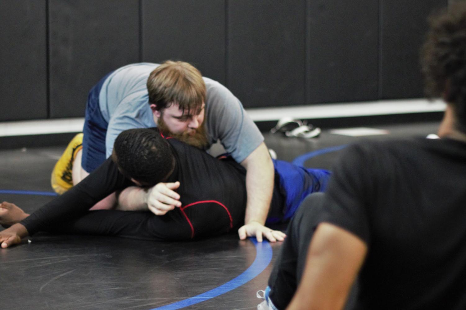 
Head wrestling coach Jacob Green performs a takedown on a student for demonstration. Practice and drills take place in the new mat room in the Hawk Arena.
