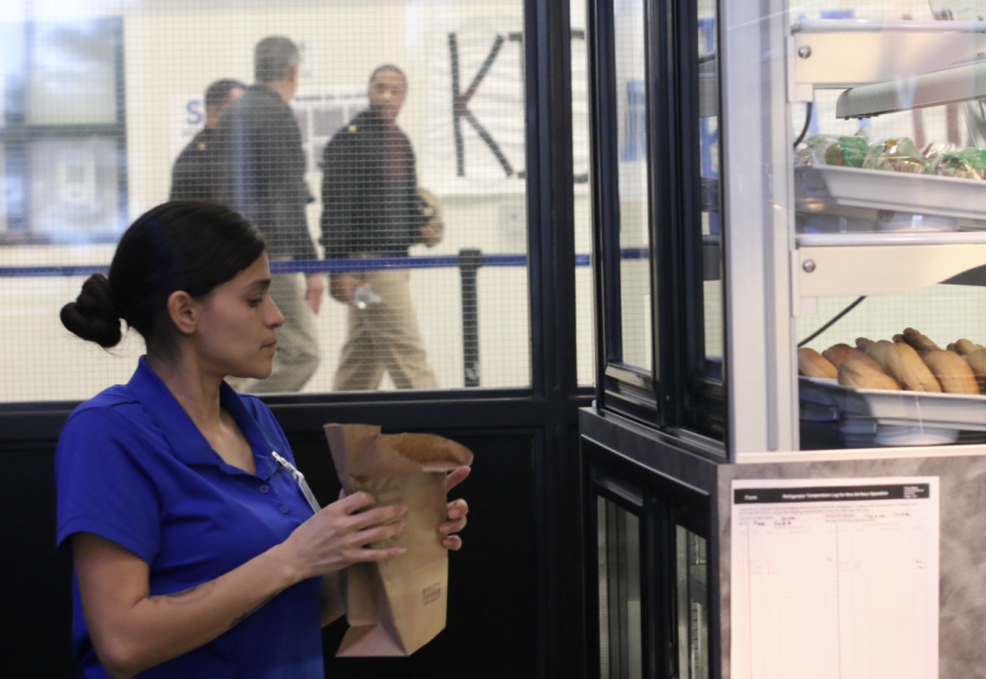 Child nutritionist and cafeteria worker Baby Rodriguez restocks supplies at the Java Cafe to get ready for customers.