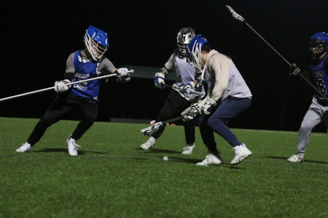 Attackers Gavyn Norwood and Michael Cortez (in white), go against defense KJ Seale and Grant Morgan (in blue) during lacrosse practice on Feb. 23 at McInnish Park.