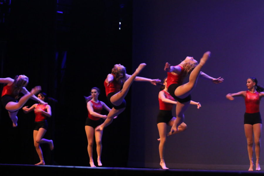 Junior Leeah Boyd and and freshman Ryann Phillips do a “firebird” jump during the gymnastics section of the big novelty dance during the spring show. The big novelty group dance was sports themed, highlighting important women in swimming, basketball, tennis and gymnastics. 