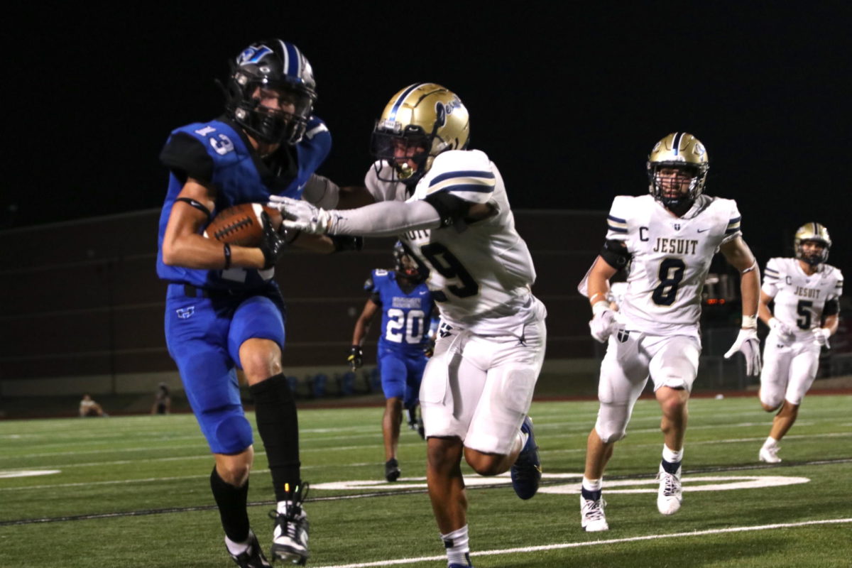 Sophomore wide receiver Tyler Hoke runs with the ball. He was tackled by a Jesuit player and did not score.