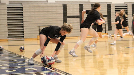 Captain Kaylin Ginsburg reaches to grab the ball during practice on Sept. 7. The players ran up and down the court, each time placing their volleyball farther down the court and then running back to their original position until they finally reached the endline, which they then turned around and did the exact same thing till they got to the other side.