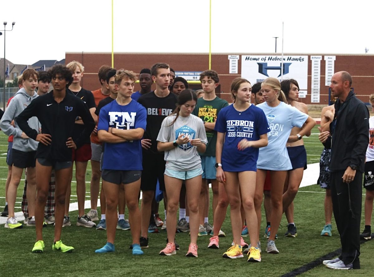 Head coach Chance Edwards strategizes with the cross country team over the district championships during practice on Oct. 12. To advance from district, the team would need to place within the top three or have an individual runner be in the top 10.