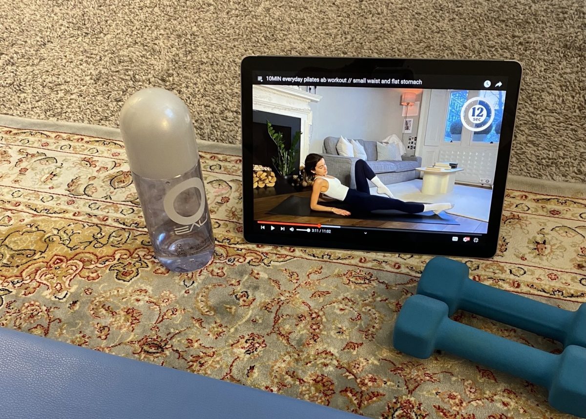 The setup of a water bottle, weights, my exercise mat and a workout video is typically how I would start my workout. This was taken in the middle of my 10 minute morning Pilate warm up.
