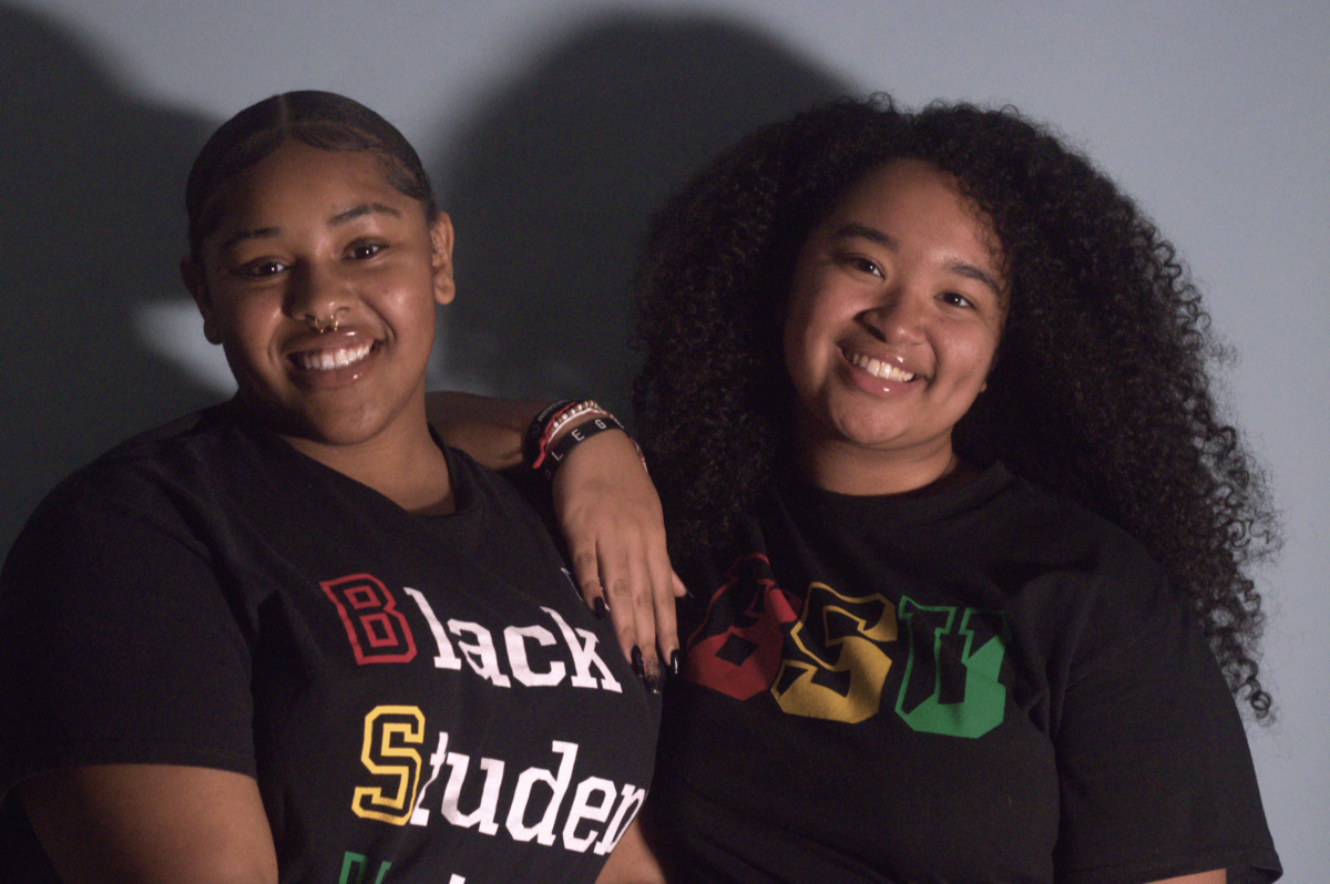 Black Student Union (BSU) vice president Harmonie Lane (left) and president Kionna Johnson (right) pose for a photo together in BSU shirts. On Sept. 6, Black Student Union announced its first all women officer team, led by Johnson and Lane.