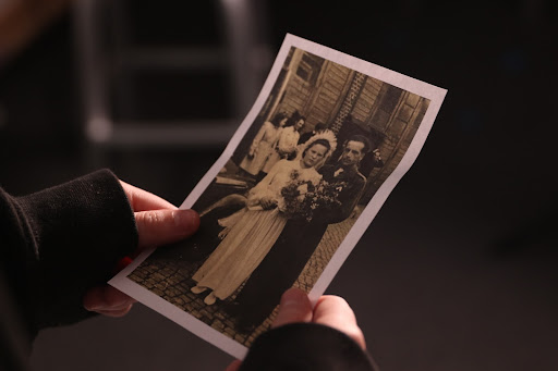  I hold a photo of my great grandmother on her wedding day. In this photo, she is wearing a traditional Polish dress, and her husband is wearing his military uniform.