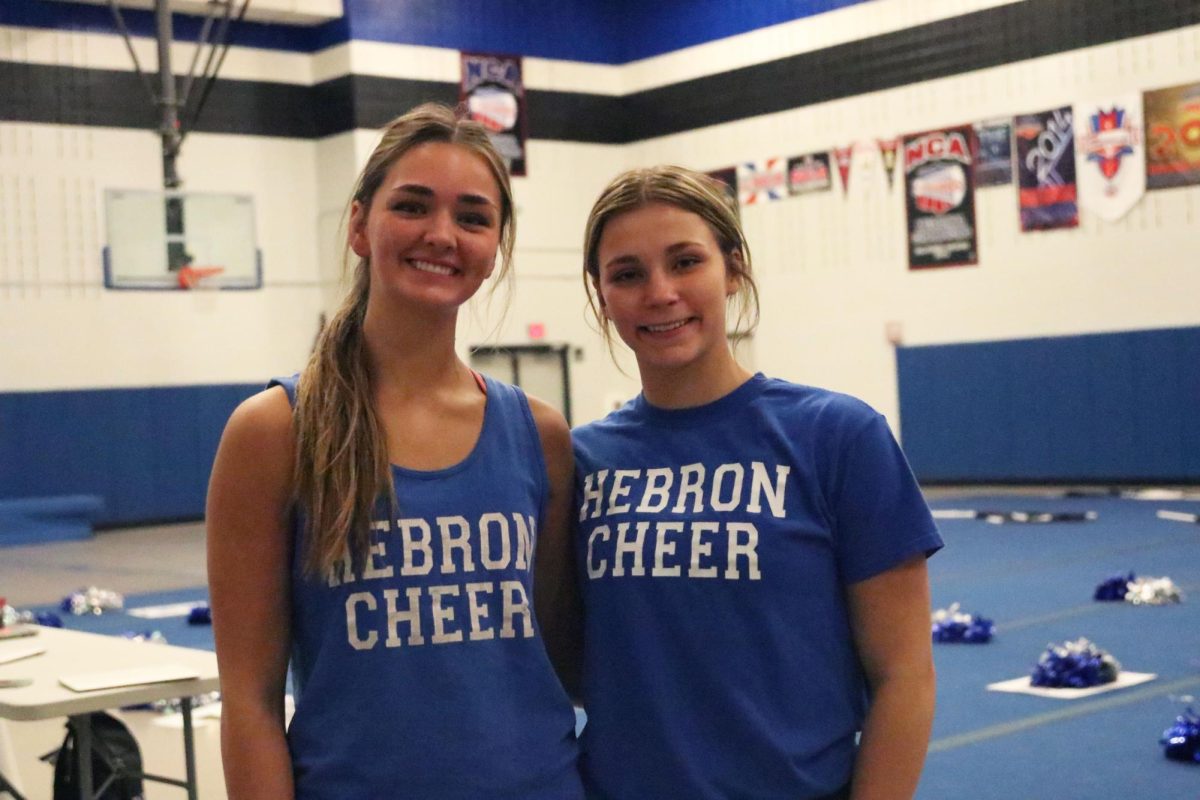 Captains Sloan Wozniak and Cate Foughty stand together after cheerleading practice on Oct. 31. The team was working on routines after school. 