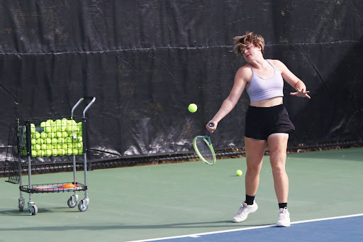 Senior Shelby Johnston feeds a ball to her student. She privately coaches a freshman junior varsity player at the Oak Creek Tennis Center.