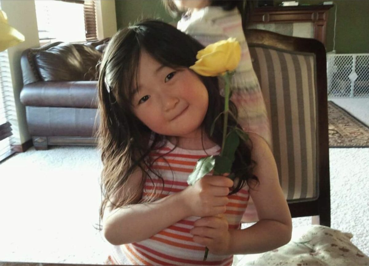 I hold a yellow flower while my sister plays behind me. It was in this house and around this age that I opened the door and told my mom that I could control the wind. 
(Rachel Mun)