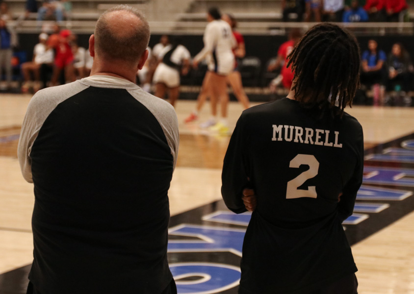 Boys basketball head coach Eric Reil talks with team manager Isaiah Murrell before the team’s game against Allen on Nov. 28. The team lost to Allen 67-64 in a tough loss, but haven’t looked back and won their last 10 games, which included Reil’s 100th win as a head coach. 