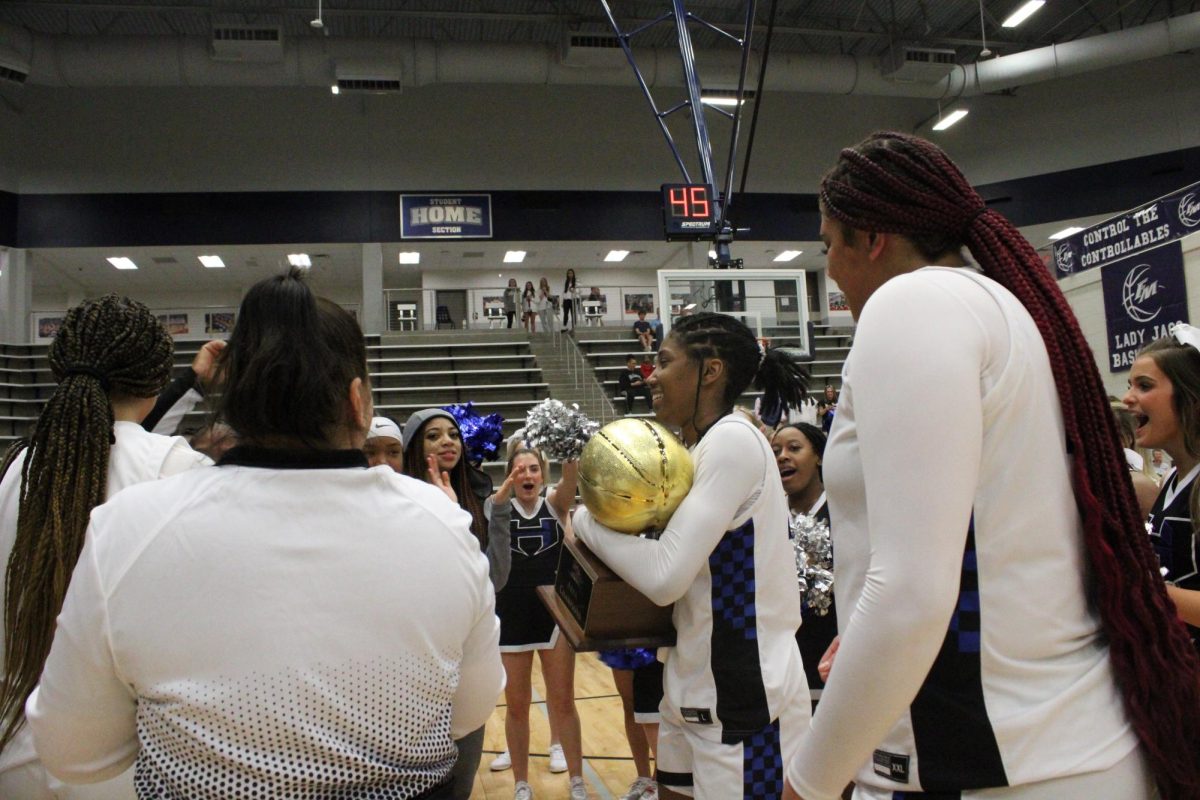 Bradley holds the trophy as the Lady Hawks defeat Little Elm in the regional quarterfinals. Last year, on this exact day, Little Elm beat the Lady Hawks in this same arena with a score of 52-65.