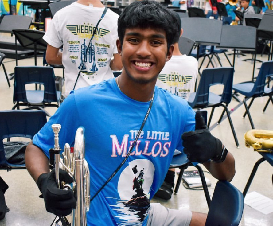 D’sa poses for a picture wearing the mellophone section shirt: The Little Mellos – a play on “The Little Mermaid.” Every year, each section in the band has a theme; they decorate lockers and shirts to fit their theme.“Spending all that time with the band really creates a whole new family,” D’sa said. “Whenever I’m in marching season my parents say ‘we’re his second family because his main family is band.’” 