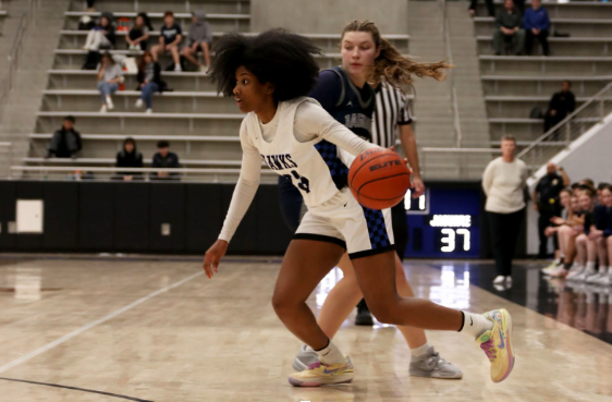Guard Paris Bradley runs the ball down court before passing to guard Micah Cooper in the last quarter of the teams’ game against Flower Mound on Jan. 9. The team won the game 57-45.