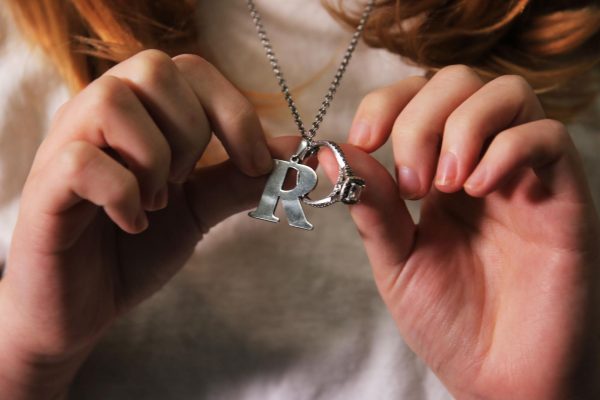  Junior Alissa Petty holds the necklace with her engagement ring and “R” charm, the initial of her fiance, junior at the Colony Ruby Rodriguez. The ring was Ruby’s grandmothers; Alissa plans to wear it on her necklace until she can get it resized. “People use the word ‘tied down’ when they talk about marriage, but that’s not what this is,” Alissa said. “I’m tied to [Ruby]. She’s my safety net — instead of falling in love, I’m being held there.”