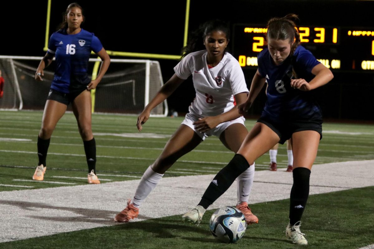 Midfielder Molly Lundy maneuvers the ball around a Coppell Midfielder on Feb. 6. The team won 3-1.