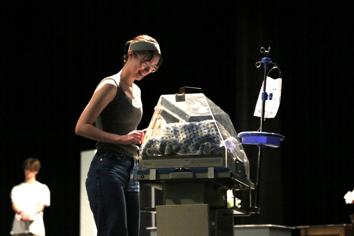  Senior Sophia Wheeler looks into the baby’s incubator at a rehearsal of “Emma’s Child” on March 6. The theater department held its public performance on March 19 and competed in the zone competition on March 20, where Hebron advanced to district.