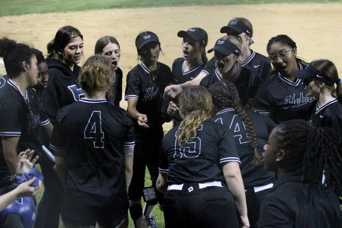 The+softball+team+huddles+together+against+Marcus+on+March+5.+The+Lady+Hawks+won+2-1%3B+it+was+the+team%E2%80%99s+first+district+win+of+the+season.+