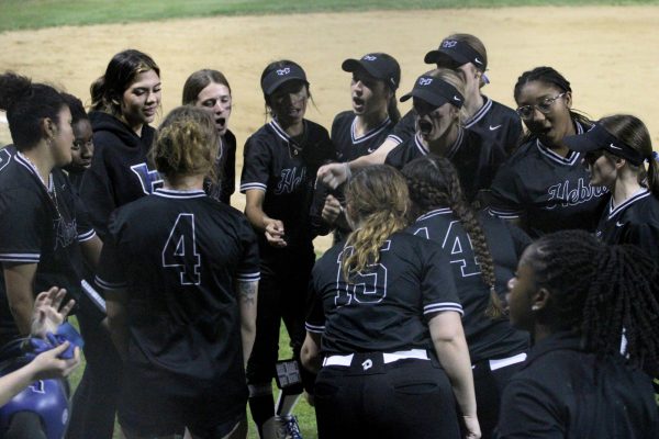 The softball team huddles together against Marcus on March 5. The Lady Hawks won 2-1; it was the team’s first district win of the season. 