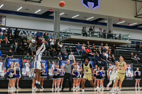 Freshman guard Parker Bolden attempts a corner three-pointer late in the fourth quarter and makes the shot to make the score 55-61 in the Hawks game against Plano East on Feb. 9. Bolden was recently named District 6-6A Newcomer of the Year by the district on March 10.