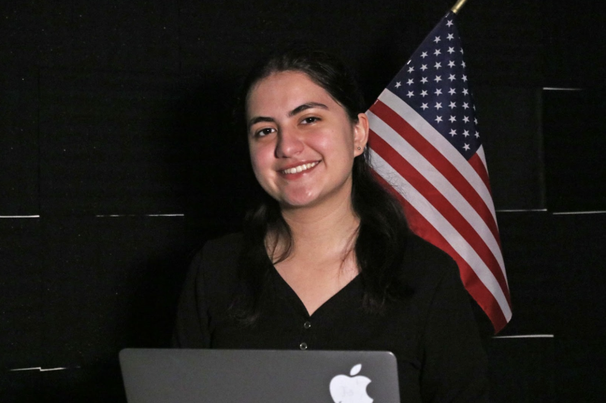 Junior Carys Sherer poses with a laptop and an American flag. To contribute to Carys’ website, one can email TheNextVoter@gmail.com. 
