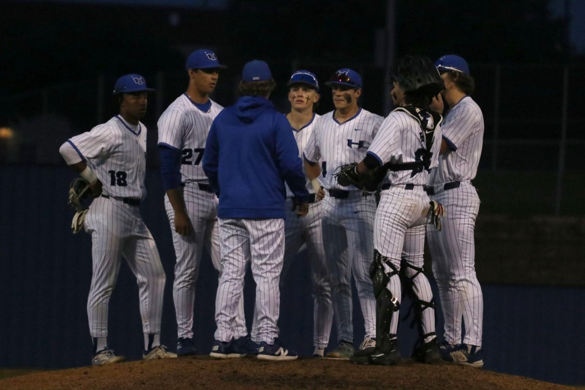 Head coach Correy Farra talks with the team after Plano made a run during the top of the third inning. The Hawks won the game 3-2.