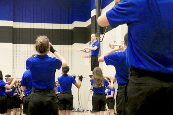 Junior Ashley Chapman conducts a group of volunteer band students. Chapman conducted the school fight song as part of her drum major audition. 