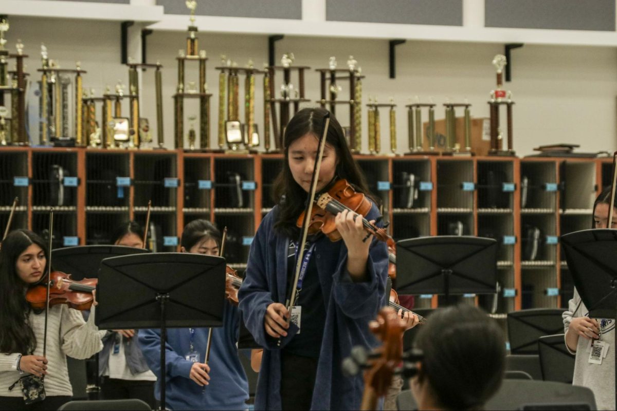  Sophomore Esther Park practices leading the orchestra before the spring concert. It will be held on May 9 at 7 p.m. at the auditorium.