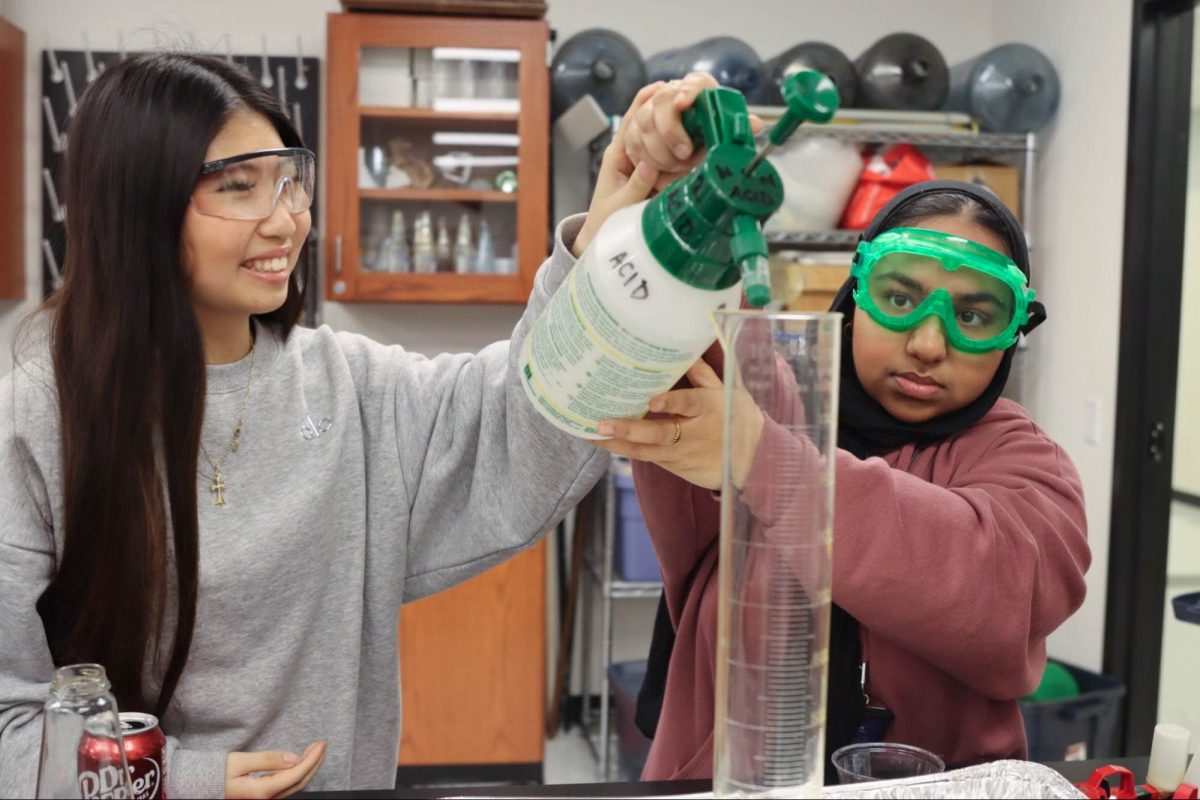 Juniors Viki Son (left) and Dua Rizvi (right) pour acid into a graduated cylinder Feb. 5 during a rehearsal after school. The demo team has been rehearsing for their science performance happening Feb. 12 at Castle Hills Elementary.
